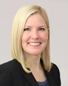 Kelly Penner, smiling, in a dark blazer.