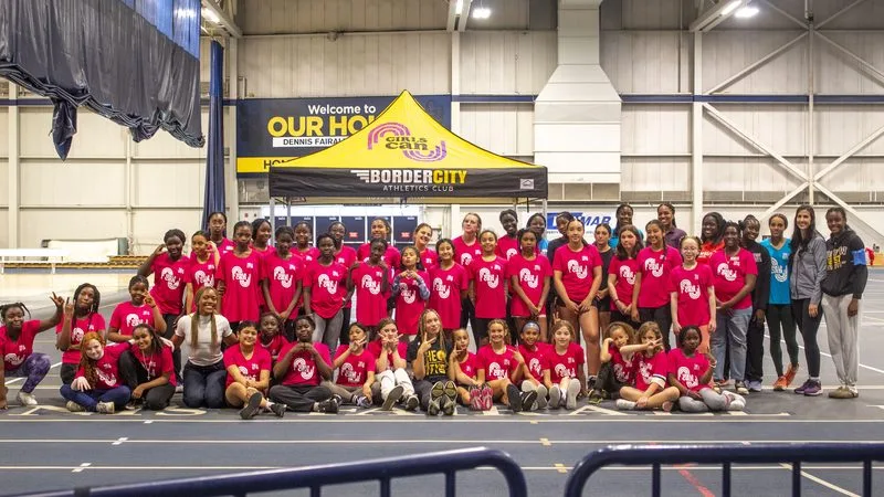 A large group of young athletes and coaches gathered in a field house.