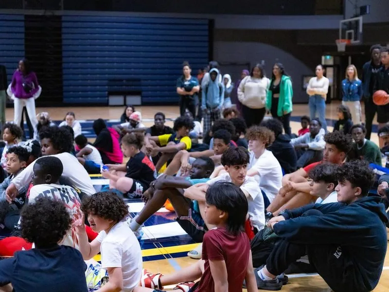 A gymnasium full of young people seated together at an MH100 youth night.